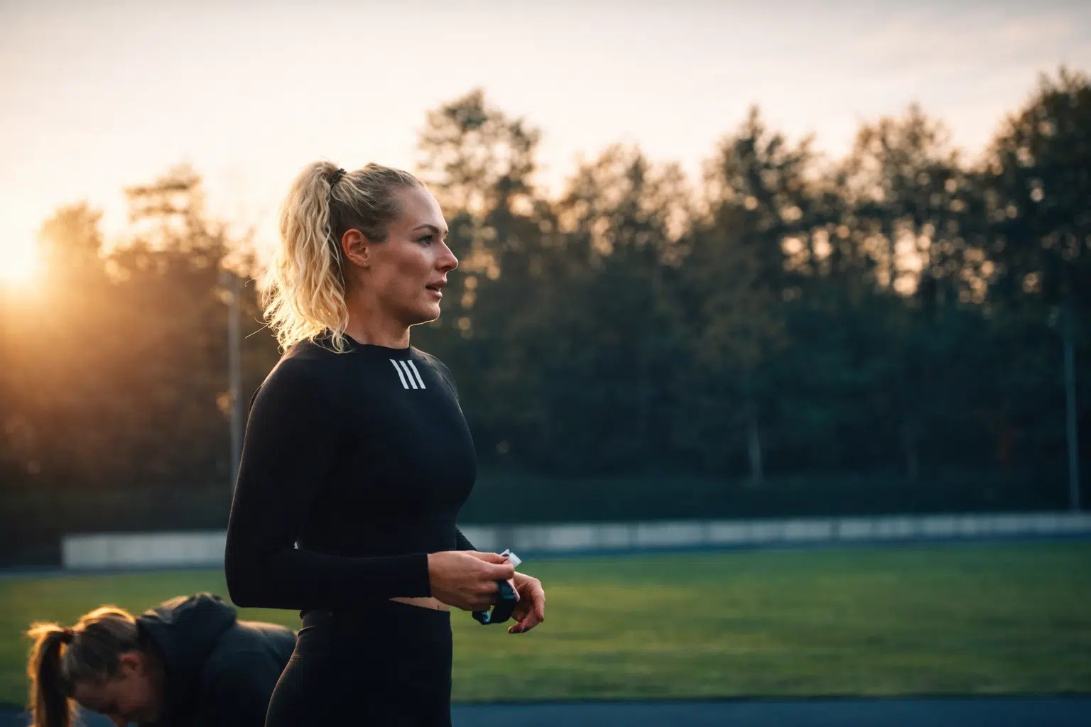 Lieke Klaver op de atletiekbaan van Papendal, bezig met warming-up en herstel in de ochtendzon.
