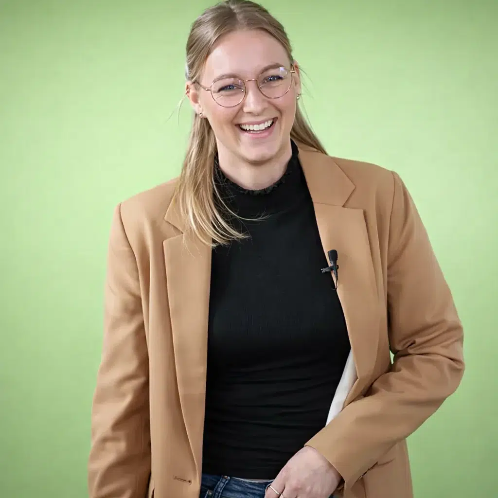 Lachende medewerker met dasspeldmicrofoon voor een groene achtergrond voor shortform content.