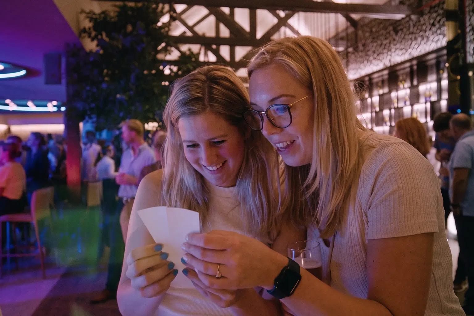 Twee mensen bekijken kaartjes in een gezellige indoor setting.